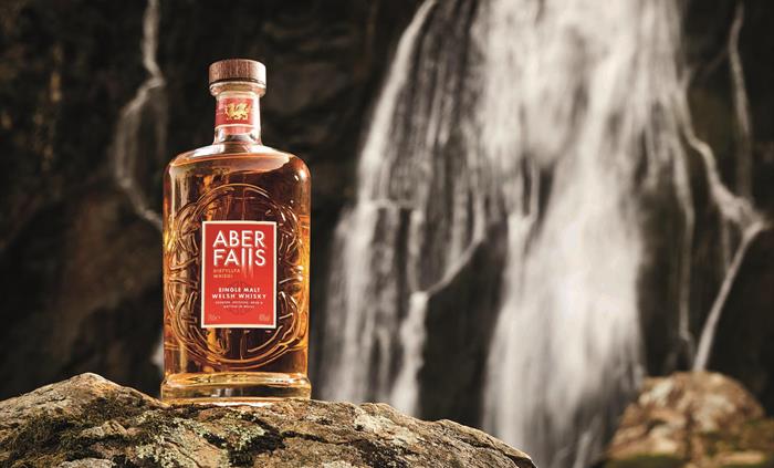 A bottle of Aber Falls Single Malt Welsh Whisky in front of Aber Falls Waterfall